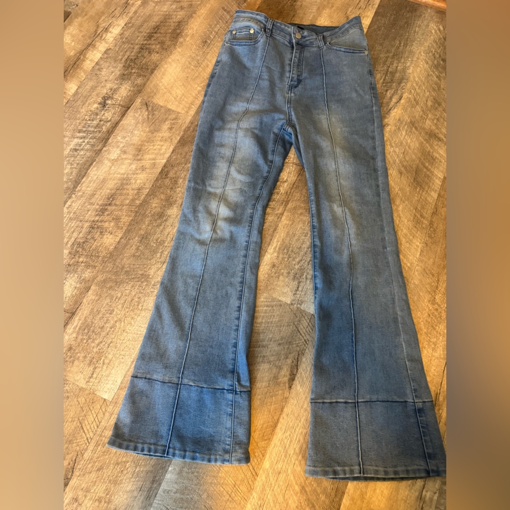 Stretchy distressed blue jeans with crease look stitching down front, flare